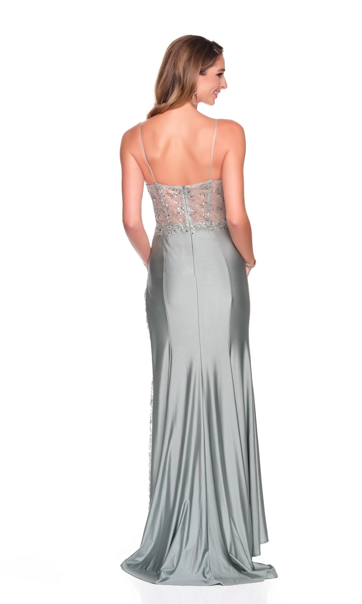 A woman faces away against a white background wearing the Dave and Johnny 12715 long prom dress in silver-gray, featuring thin straps, an embellished corset bodice, and a sheer back.